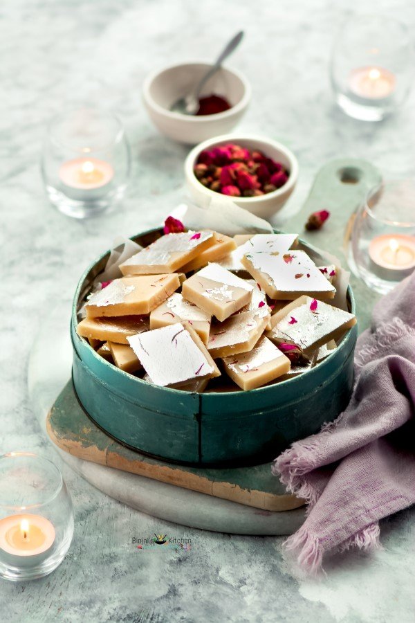 A bowl filled with assorted homemade fudge pieces on a marble surface.